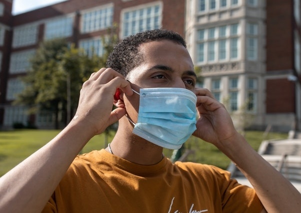 Black guy putting on a facemask